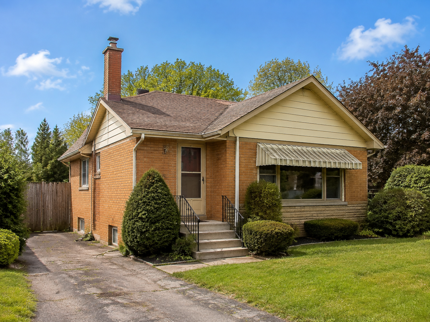 Illustrative older detached brick home with dated finishes, a front lawn and a driveway