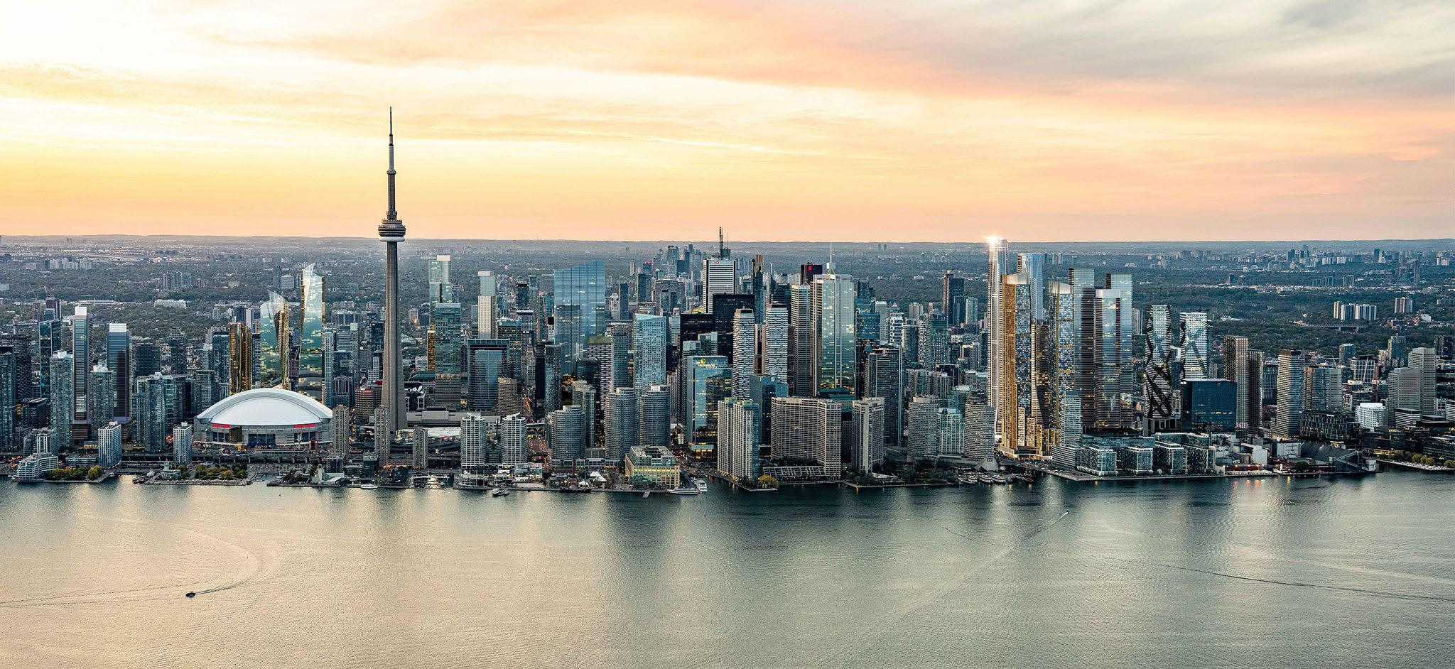 Toronto waterfront skyline at sunset, with Rogers Centre beside the CN Tower